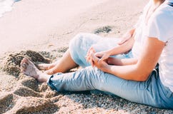 Close up of couple sitting sitting on the sand on the beach and holding hands. Summer love concept. Holiday relaxing, beach royalty free stock photos Close up of couple sitting sitting on the sand on the beach and holding hands. Summer love concept. Holiday relaxing, beach royalty free stock photos