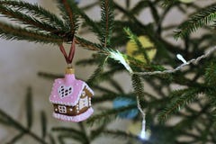 Close-up da casa de pão-de-espécie que pendura na árvore de Natal uma árvore de Natal viva imagens de stock Close-up da casa de pão-de-espécie que pendura na árvore de Natal uma árvore de Natal viva imagens de stock
