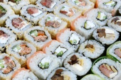 Close-up de muitos rolos de sushi com enchimentos diferentes Tiro macro do alimento japonês clássico cozinhado Imagem de fundo fotografia de stock royalty free Close-up de muitos rolos de sushi com enchimentos diferentes Tiro macro do alimento japonês clássico cozinhado Imagem de fundo fotografia de stock royalty free