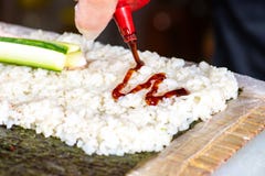 Close-up die van chef-kokhanden die sushi op de keuken oprollen, saus toevoegen royalty-vrije stock afbeeldingen Close-up die van chef-kokhanden die sushi op de keuken oprollen, saus toevoegen royalty-vrije stock afbeeldingen