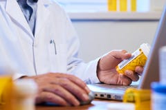 Doctor writing out prescription on a laptop royalty free stock photos Doctor writing out prescription on a laptop royalty free stock photos