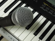 Close-up of a dynamic vocal microphone and a digital keyboard. royalty free stock photos Close-up of a dynamic vocal microphone and a digital keyboard. royalty free stock photos