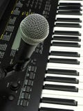 Close-up of a dynamic vocal microphone and a digital keyboard. stock image Close-up of a dynamic vocal microphone and a digital keyboard. stock image