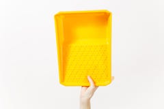 Close up of female hand vertical holds orange paint tray isolated on white background. Instruments, accessories, tools royalty free stock photo Close up of female hand vertical holds orange paint tray isolated on white background. Instruments, accessories, tools royalty free stock photo