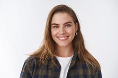 Close-up friendly-looking happy positive lucky young female wearing checked shirt over t-shirt smiling broadly delighted stock photo Close-up friendly-looking happy positive lucky young female wearing checked shirt over t-shirt smiling broadly delighted stock photo