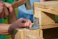 Close up of hammering a nail into wooden board royalty free stock photography Close up of hammering a nail into wooden board royalty free stock photography