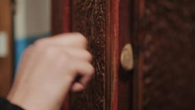 Close-up of hand knocking on door