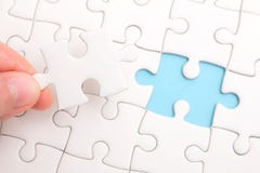 Close up of hand placing the last jigsaw puzzle piece royalty free stock image Close up of hand placing the last jigsaw puzzle piece royalty free stock image