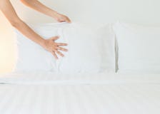 Close up hand set up white bed sheet in hotel room stock photos Close up hand set up white bed sheet in hotel room stock photos