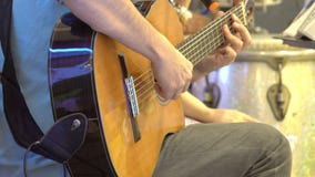 Close up of hands of a man playing a classic guitar on stage. Close up of hands of a man playing a classic guitar on stage.