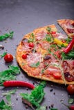 A close-up of hot margarita pizza on a dark background. Cut Italian pizza with vegetables and meat. Copy space. stock photo A close-up of hot margarita pizza on a dark background. Cut Italian pizza with vegetables and meat. Copy space. stock photo