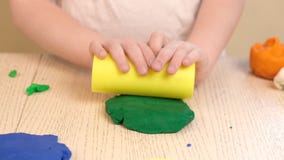 Close up of kids hands molding colorful childs play clay. Learning educational activities for children at home, in kindergarten.