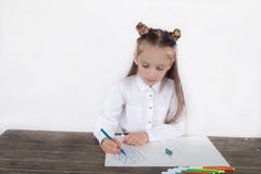 Close up of little girl in white blouse which is focused on drawing. Preschooler is learning how to draw. Kindergarten and school. Family fun royalty free stock photo Close up of little girl in white blouse which is focused on drawing. Preschooler is learning how to draw. Kindergarten and school. Family fun royalty free stock photo