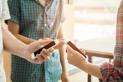 Close up of men and woman hands holding touching mobile phone with blank copy space for your text message in cafe with light Sun stock photography Close up of men and woman hands holding touching mobile phone with blank copy space for your text message in cafe with light Sun stock photography