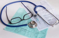 Close up needle syringe and medical stethoscope with glasses on blood chart prescription paper Royalty Free Stock Photography Close up needle syringe and medical stethoscope with glasses on blood chart prescription paper Royalty Free Stock Photography