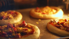 Close-up, o processo de cozer a mini pizza da massa de fermento em um grande forno industrial Pão de cozimento em um industrial video estoque Close-up, o processo de cozer a mini pizza da massa de fermento em um grande forno industrial Pão de cozimento em um industrial video estoque