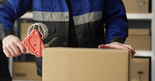 Close Up Of Hands Of Caucasian Postal Male Worker In Uniform Packing Carton Box At Delievery Department In Post Office Stock Images