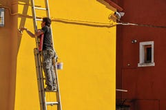 Close-up Of Painter Painting Wall Of House Of Yellow In Burano. Royalty Free Stock Photography Close-up Of Painter Painting Wall Of House Of Yellow In Burano. Royalty Free Stock Photography