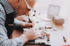 Close up. Old Man Repairing Motherboard from PC royalty free stock photos Close up. Old Man Repairing Motherboard from PC royalty free stock photos