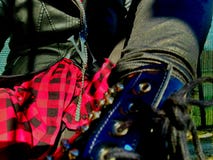 Close-up op details, de doeken en de toebehoren van de punkmuziek de betoverende stijl - meisjeslaars, rood overhemd en zwart lee royalty-vrije stock fotografie Close-up op details, de doeken en de toebehoren van de punkmuziek de betoverende stijl - meisjeslaars, rood overhemd en zwart lee royalty-vrije stock fotografie