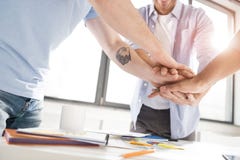 Close-up partial view of businessmen stacking hands while working on project together stock image Close-up partial view of businessmen stacking hands while working on project together stock image