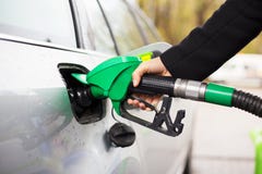 Close-up photo of hand holding fuel pump and refilling car at petrol station royalty free stock photo Close-up photo of hand holding fuel pump and refilling car at petrol station royalty free stock photo