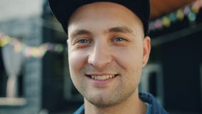 Close-up portrait of attractive adult man smiling standing outdoors in street stock video footage Close-up portrait of attractive adult man smiling standing outdoors in street stock video footage