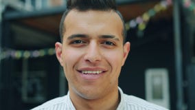Close-up portrait of attractive young Arab smiling looking at camera outdoors stock footage Close-up portrait of attractive young Arab smiling looking at camera outdoors stock footage