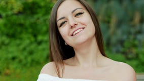 Close-up portrait of beautiful shy woman smiles to the camera on the street stock video footage Close-up portrait of beautiful shy woman smiles to the camera on the street stock video footage
