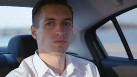 Close-up Portrait of Businessman Traveling in a Car with a Driver. Young Man in white shirt rides in a Taxi stock video Close-up Portrait of Businessman Traveling in a Car with a Driver. Young Man in white shirt rides in a Taxi stock video