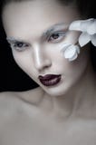 Frontal view of beauty portrait artistic makeup, burgundy lips, face, near white flower, isolated on black background. stock image Frontal view of beauty portrait artistic makeup, burgundy lips, face, near white flower, isolated on black background. stock image