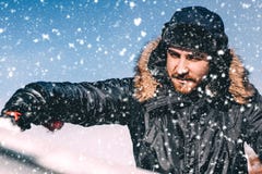 Close up portrait of winter concept - man cleaning car from snow, wearing hat and warm jacket royalty free stock image Close up portrait of winter concept - man cleaning car from snow, wearing hat and warm jacket royalty free stock image