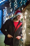 Close up portrait of young smiling man, with santa claus cap sta. Nding next to Christmas lights decoration Stock Image Close up portrait of young smiling man, with santa claus cap sta. Nding next to Christmas lights decoration Stock Image