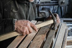 Close Up Shot Of Master Carpenter Working In His Woodwork Or Workshop. Hammer In Old Hand Stock Image
