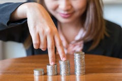 Close up smile business woman with savings coins on table - finance concept stock images Close up smile business woman with savings coins on table - finance concept stock images