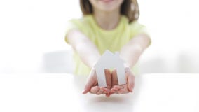 Close-up of smiling girl holding paper house