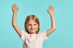 Close-up studio shot of a lovely blonde little girl in a white t-shirt posing against a blue background. stock image Close-up studio shot of a lovely blonde little girl in a white t-shirt posing against a blue background. stock image