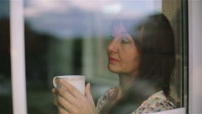 Close up. Thoughtful sad brunette woman outside drinking warm morning tea and  dreaming.