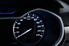Close-up van de snelheidsmeter op het dashboard van een moderne dure auto De dashboardverlichting wordt weerspiegeld royalty-vrije stock fotografie Close-up van de snelheidsmeter op het dashboard van een moderne dure auto De dashboardverlichting wordt weerspiegeld royalty-vrije stock fotografie