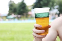 Close-up van een mannelijk bier van de handholding met vaag zwembad i stock afbeelding Close-up van een mannelijk bier van de handholding met vaag zwembad i stock afbeelding