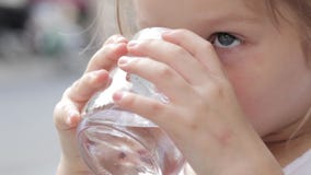 Close-up van een weinig leuk meisje die zuiver water van een glas drinken stock videobeelden Close-up van een weinig leuk meisje die zuiver water van een glas drinken stock videobeelden
