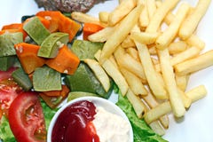 Close-up view of fried beef meat and fish with potatoes and vegetables lying on the table for lunch. stock photography Close-up view of fried beef meat and fish with potatoes and vegetables lying on the table for lunch. stock photography
