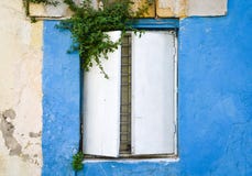 Ancien rusty metal window at an old house with painted blue walls royalty free stock photography Ancien rusty metal window at an old house with painted blue walls royalty free stock photography