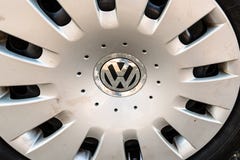 Close up of Volkswagen logo on a dented wheel