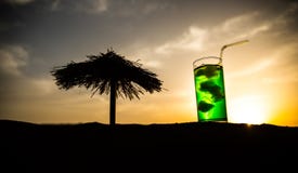 Close up wet glass of green cold mint drink, colorful orange sunset background on the terrace. Cooling summer drink. Summer fresh royalty free stock photos Close up wet glass of green cold mint drink, colorful orange sunset background on the terrace. Cooling summer drink. Summer fresh royalty free stock photos
