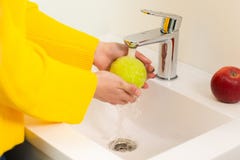 Close up of women`s hands washing green apple in sink royalty free stock photo Close up of women`s hands washing green apple in sink royalty free stock photo