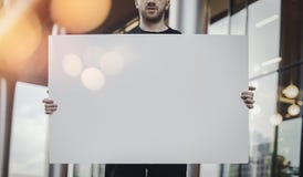 Close up of attractive man horizontally holding blank canvas at the street. royalty free stock photos Close up of attractive man horizontally holding blank canvas at the street. royalty free stock photos