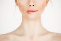 Close up of young beautiful girl with clean healthy skin biting lip over white background. Copy space. Cosmetology and stock photos Close up of young beautiful girl with clean healthy skin biting lip over white background. Copy space. Cosmetology and stock photos