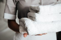 Close up of a young maid holding folded towels royalty free stock photography Close up of a young maid holding folded towels royalty free stock photography
