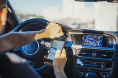 Close up of young man looking at GPS navigator behind the wheel in car. stock photo Close up of young man looking at GPS navigator behind the wheel in car. stock photo